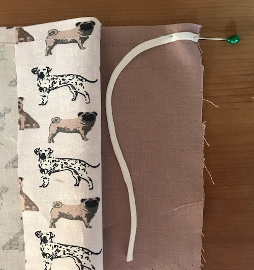 Pin one end of the elastic to the right side of the backing fabric