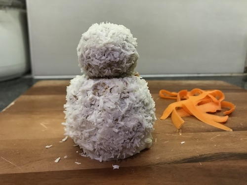 Roll the balls covered with cream cheese in shredded coconut to coat